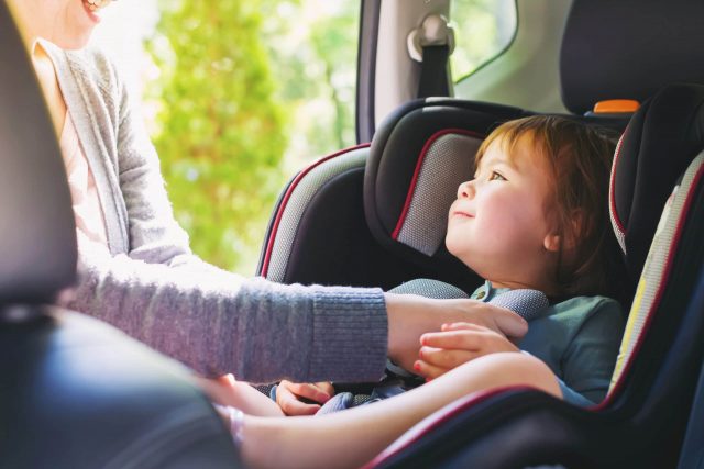 un enfant dans sa voiture familialle