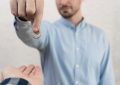 Un homme en chemise bleue remet son alliance à une autre personne, symbolisant les démarches pour un divorce rapide.