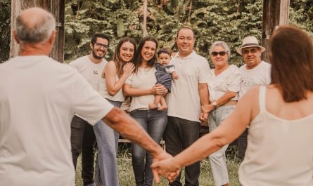 a group of people holding hands in front of trees