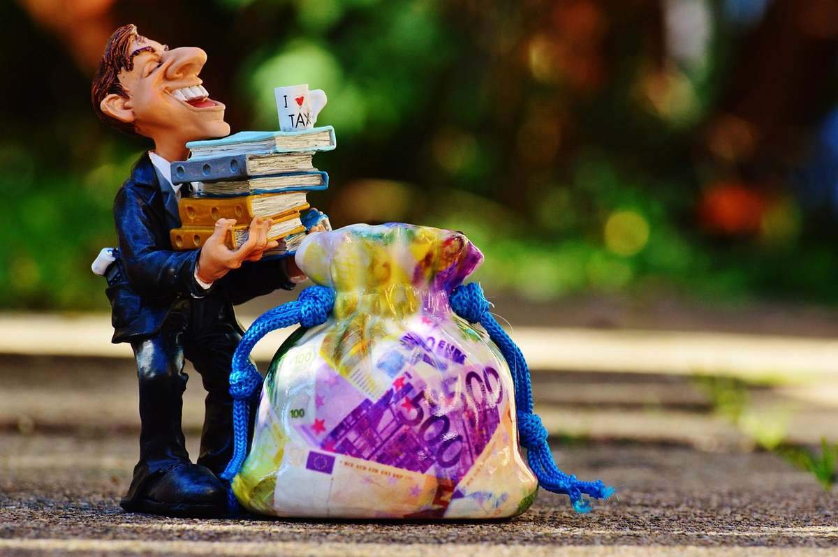 Figurine d'homme avec un sac d'argent et des livres, trottoir