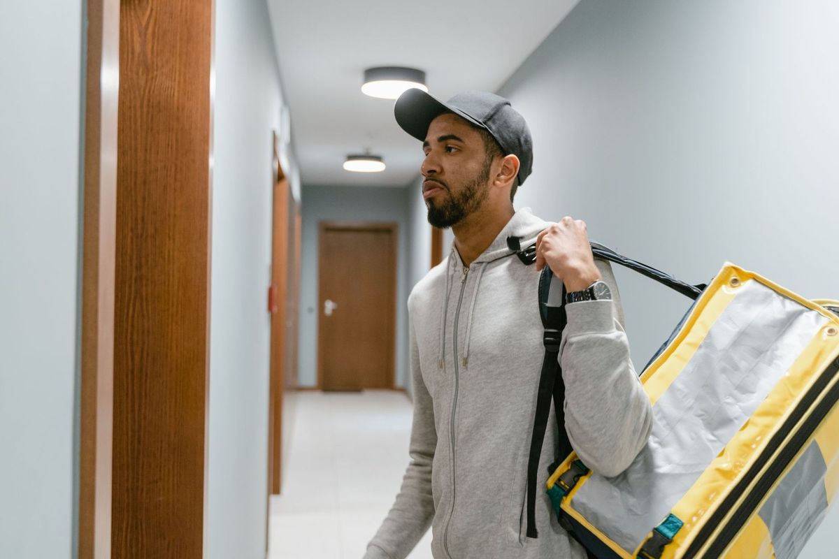 Homme portant un sac à dos jaune dans un couloir